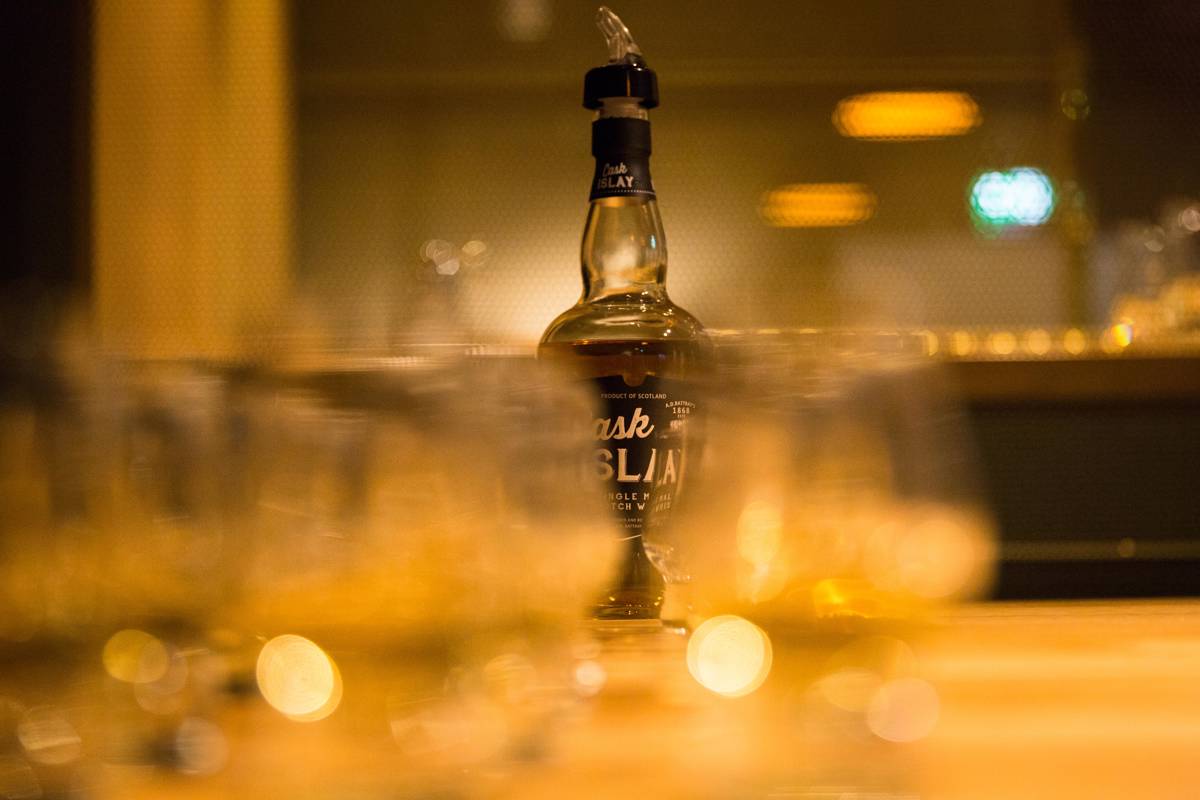 Whisky station set up with bottle of Cask Islay against blurred out dram glasses 