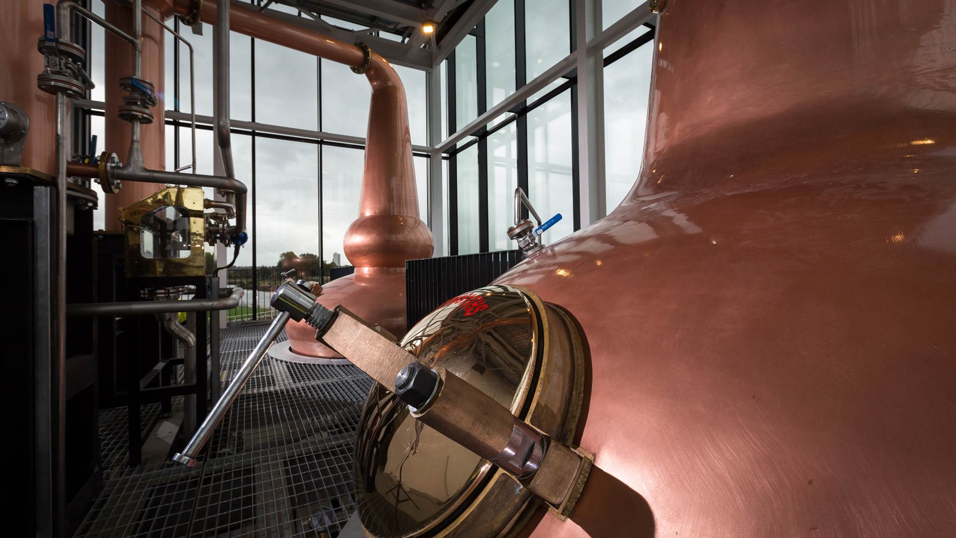 The Clydeside Distillery’s glass Still House with two tall copper stills