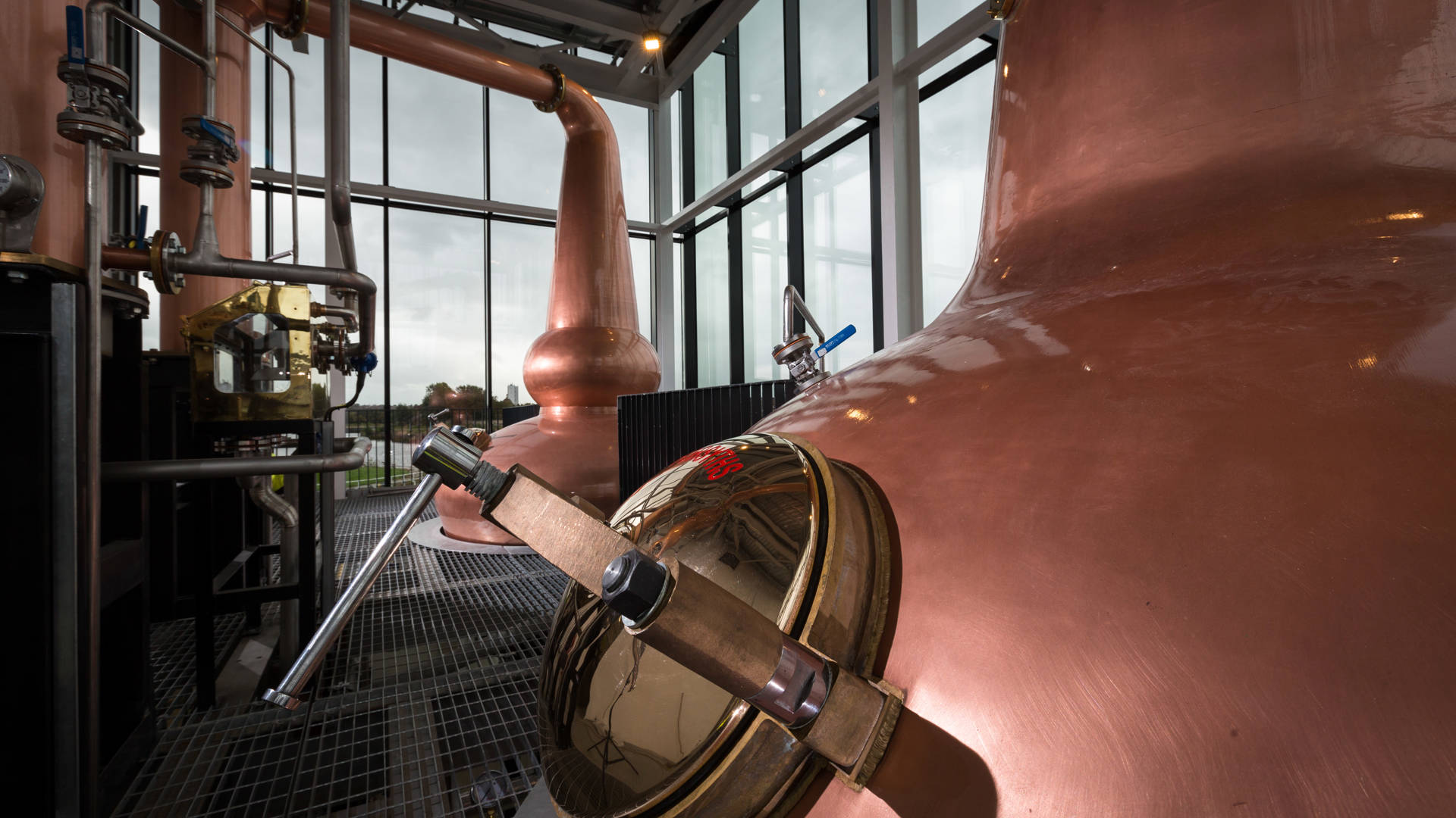The Clydeside Distillery’s glass Still House with two tall copper stills