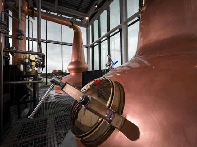 The Clydeside Distillery’s glass Still House with two tall copper stills