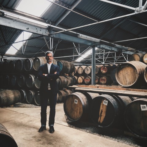 a man standing in a whisky warehouse