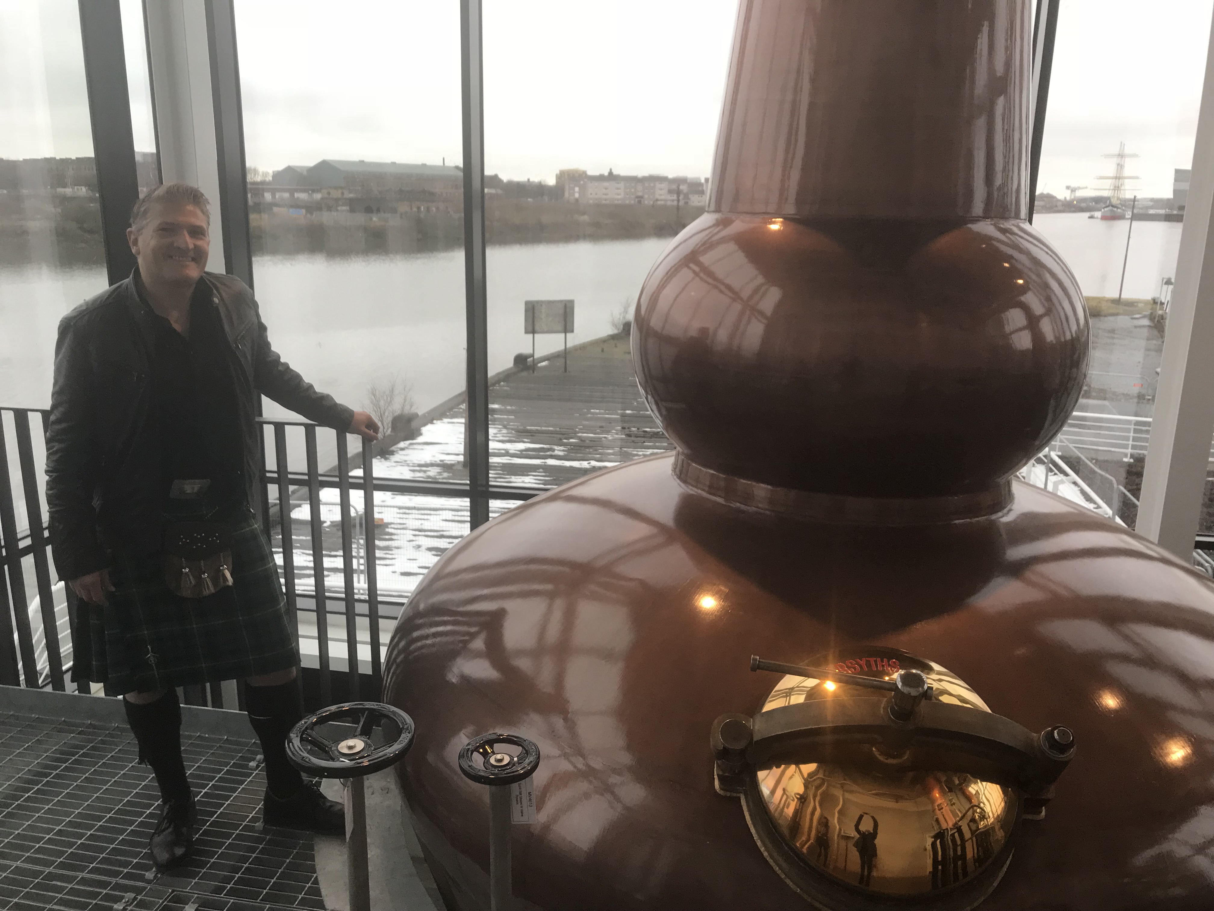 a man standing next to a distillation system 