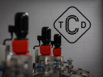 The Clydeside Distillery’s mash house with stainless-steel washbacks with company logo on wall 